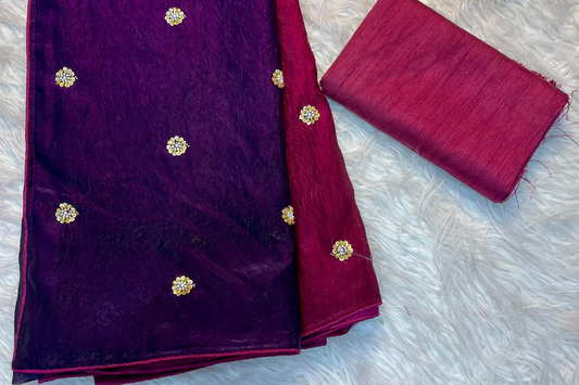 Purple fabric with gold embellishments and a matching red fabric on a white textured background